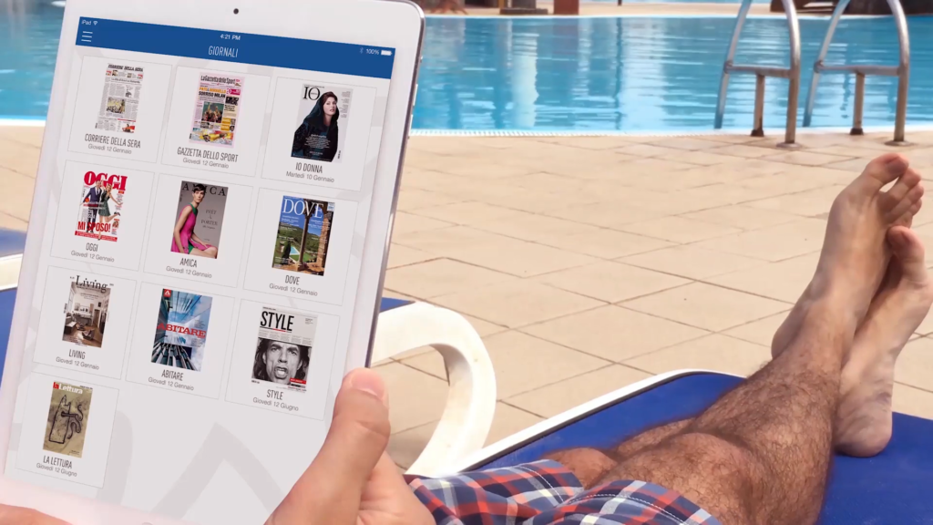 Man lying on a sun-bed and reading free digital content from Quibee. 