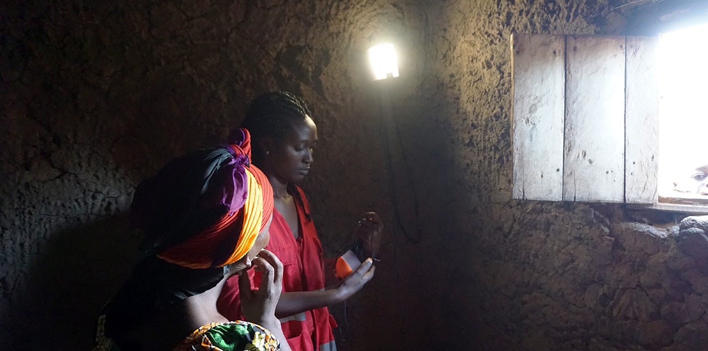 African woman in a dark room lit only by nowlight developed by startup Deciwatt