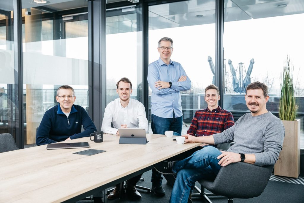 The Kraftblock team around a desk in their office. 