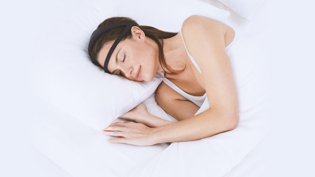 The Dreem Headband Gadget Being Worn by a Sleeping Woman.