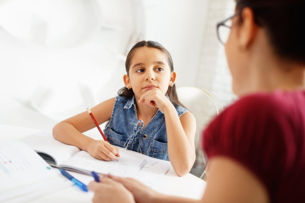 Homeschooling, mother helping her daughter with homework