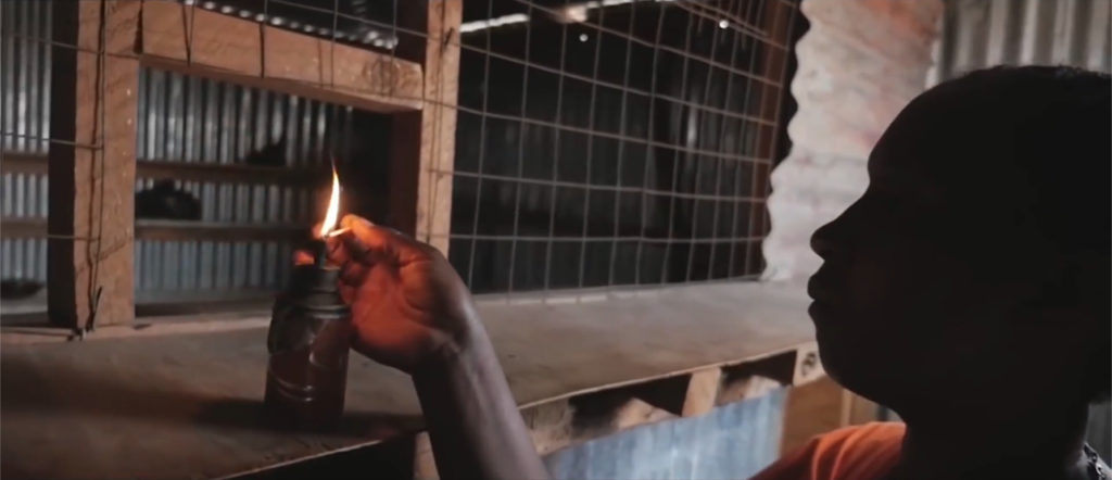 A woman lights an oil lamp in a village in Nigeria. Courtesy of Havenhill Synergy